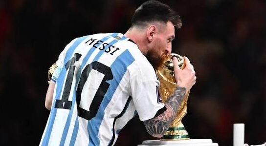 Lionel Messi holding the FIFA World Cup trophy in 2022 with Argentina with motivational quote overlay about comeback and greatness